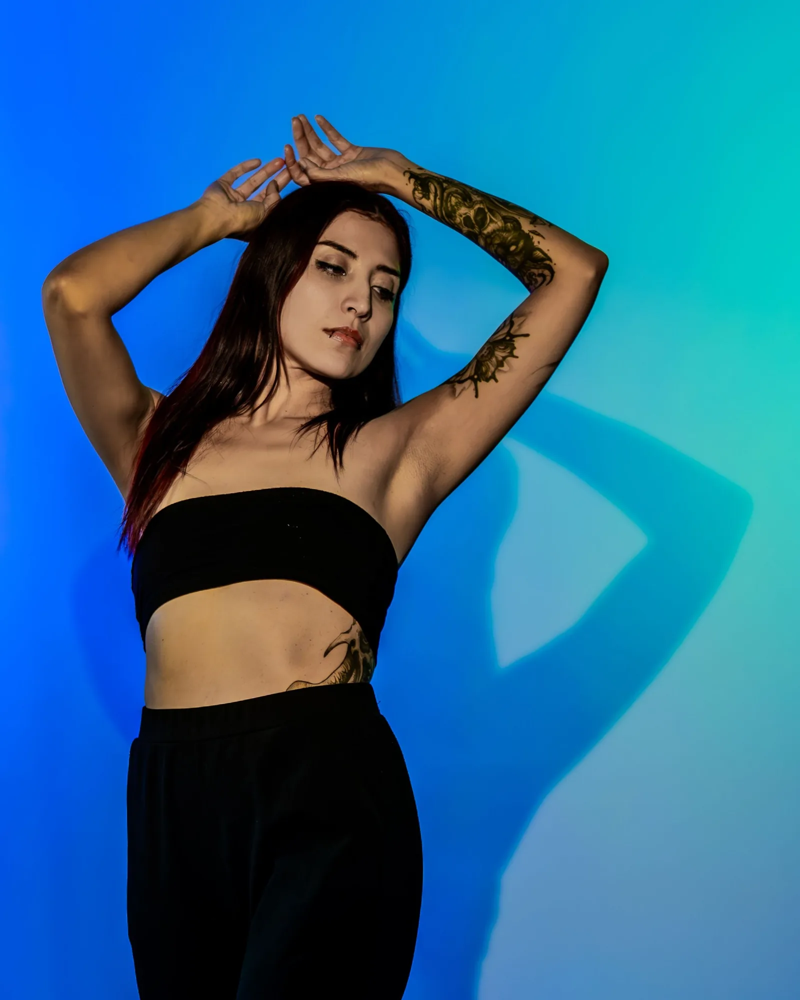 Model posing in teal and blue studio light