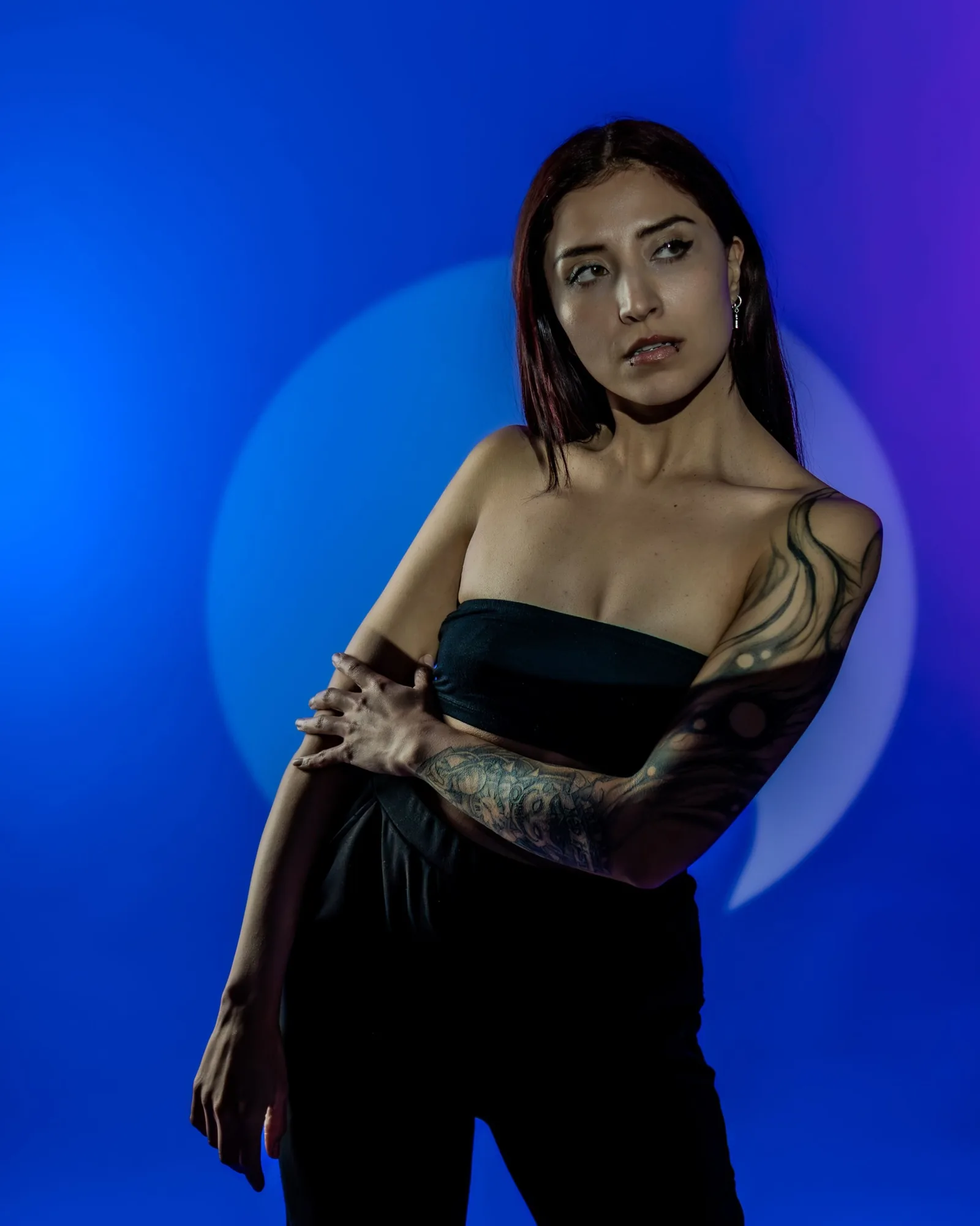 Model in a black top against a blue circle of light