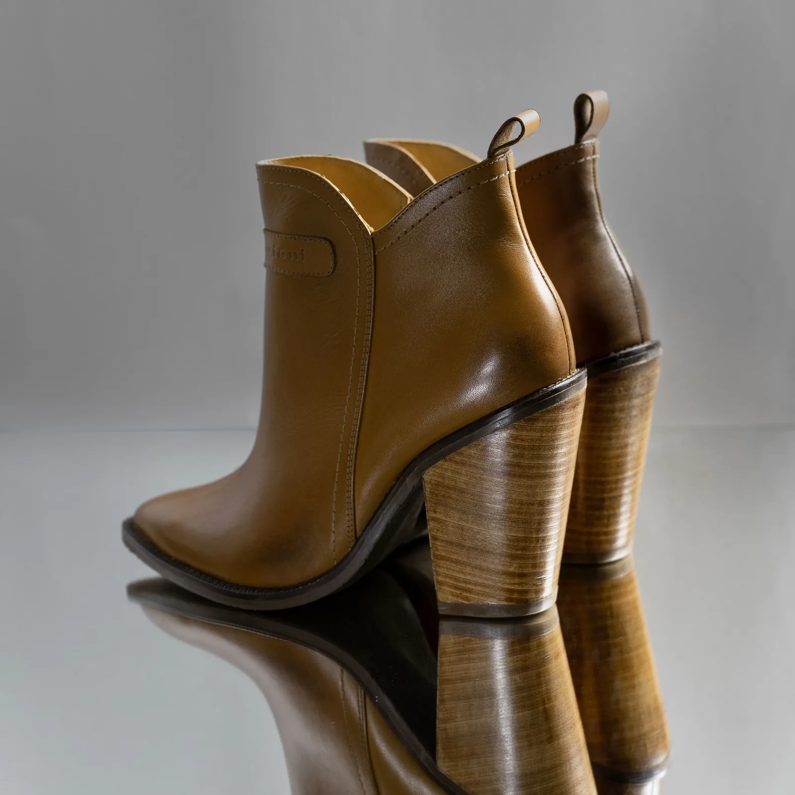 Tan leather ankle boots on a grey background