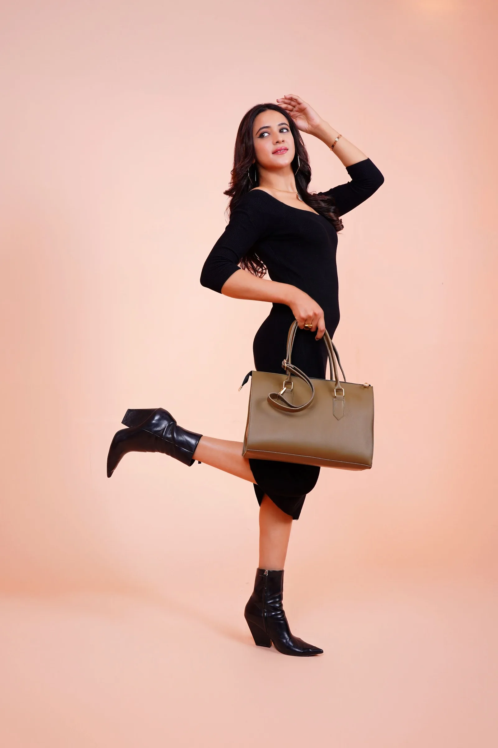 Model mid step with a small tan bag