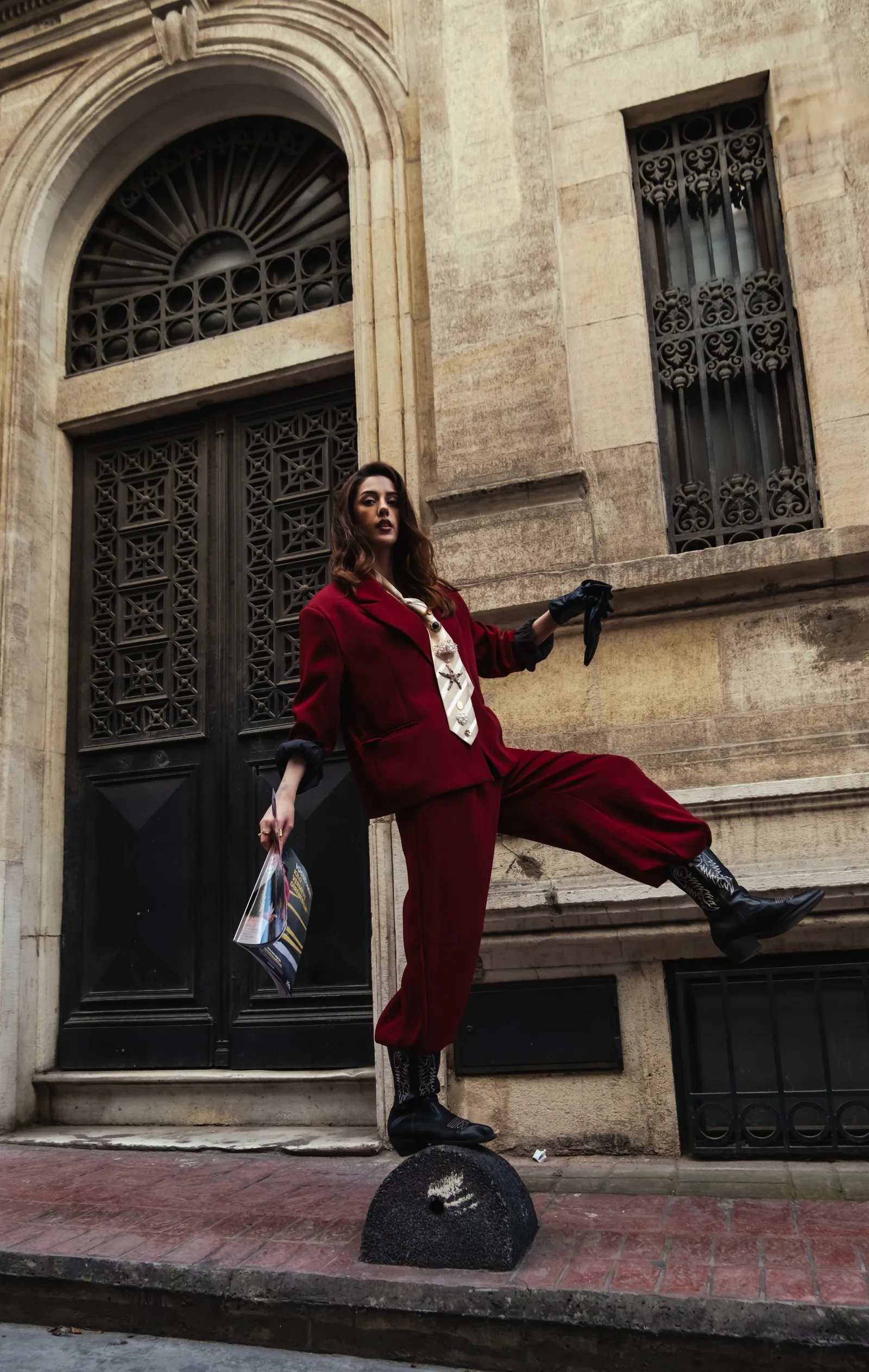 Model in a red suit posing in front of an old doorway